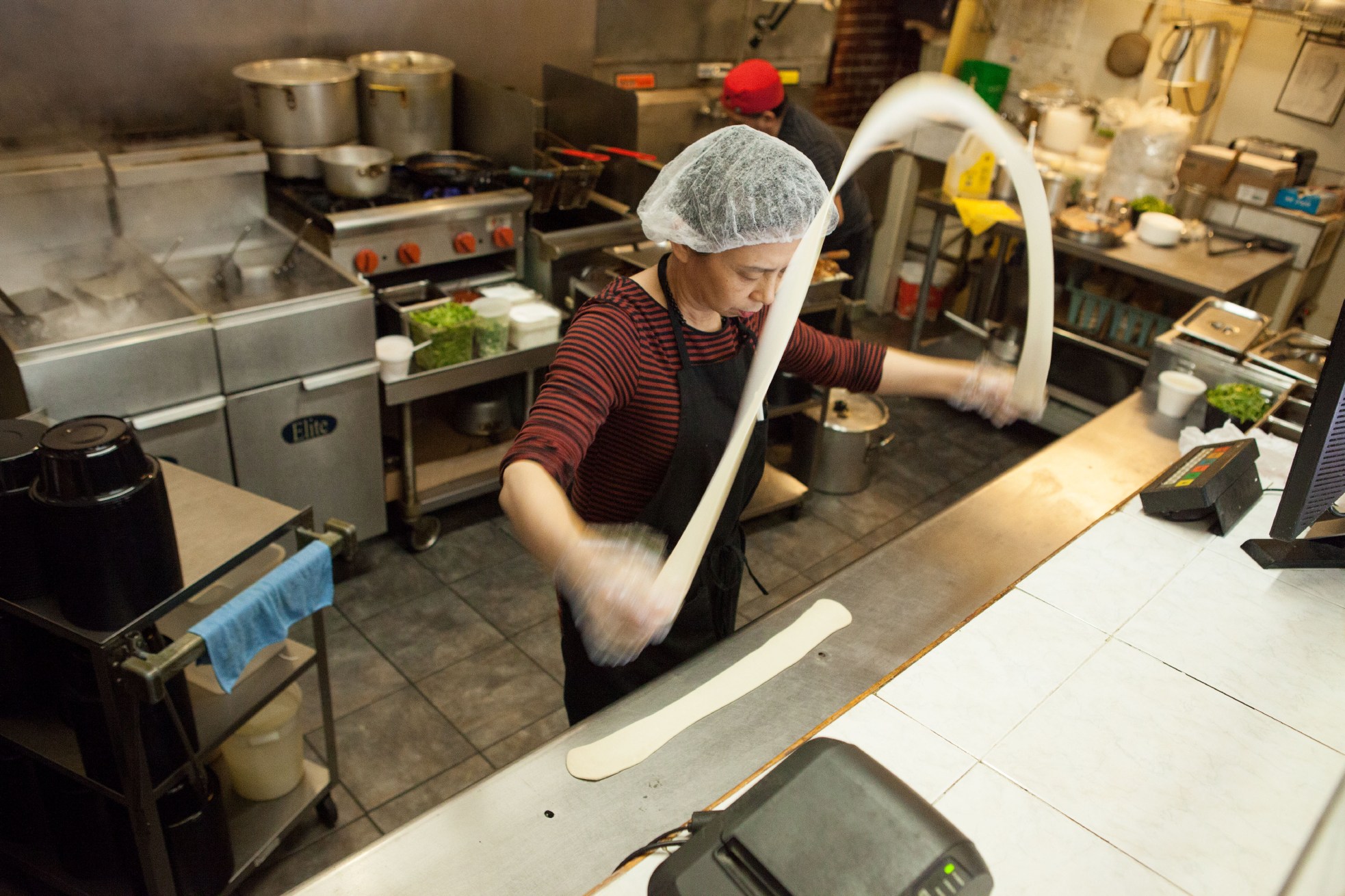 A cook pulling noodles at Gene’s Chinese Flatbread Café in Boston, MA.