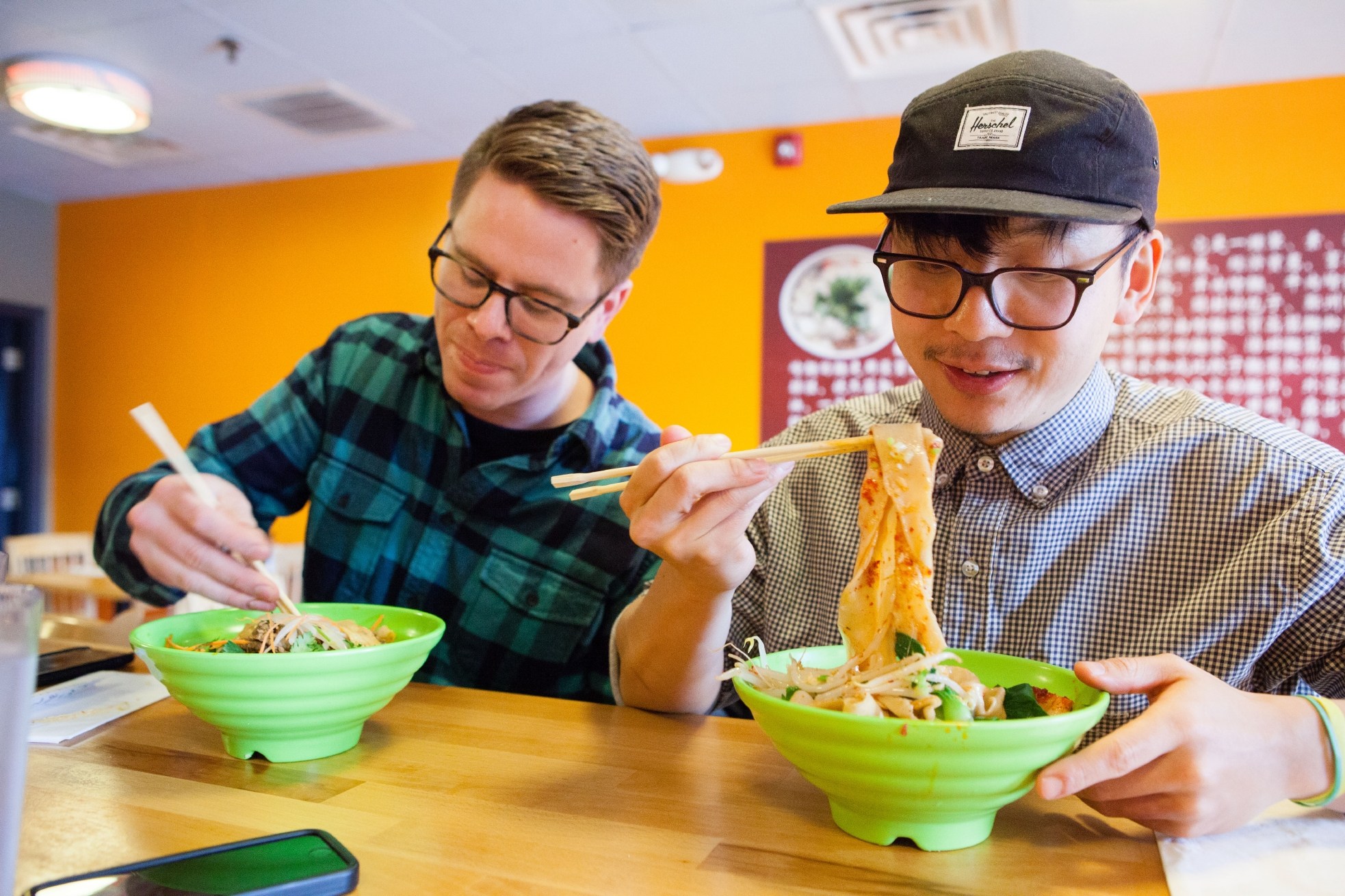 Associate editor Tim Chin and test cook Sasha Marx sample hand-pulled noodle dishes at MDM Noodles in Brighton, MA as they do research for a new recipe featuring this uniquely prepared food.