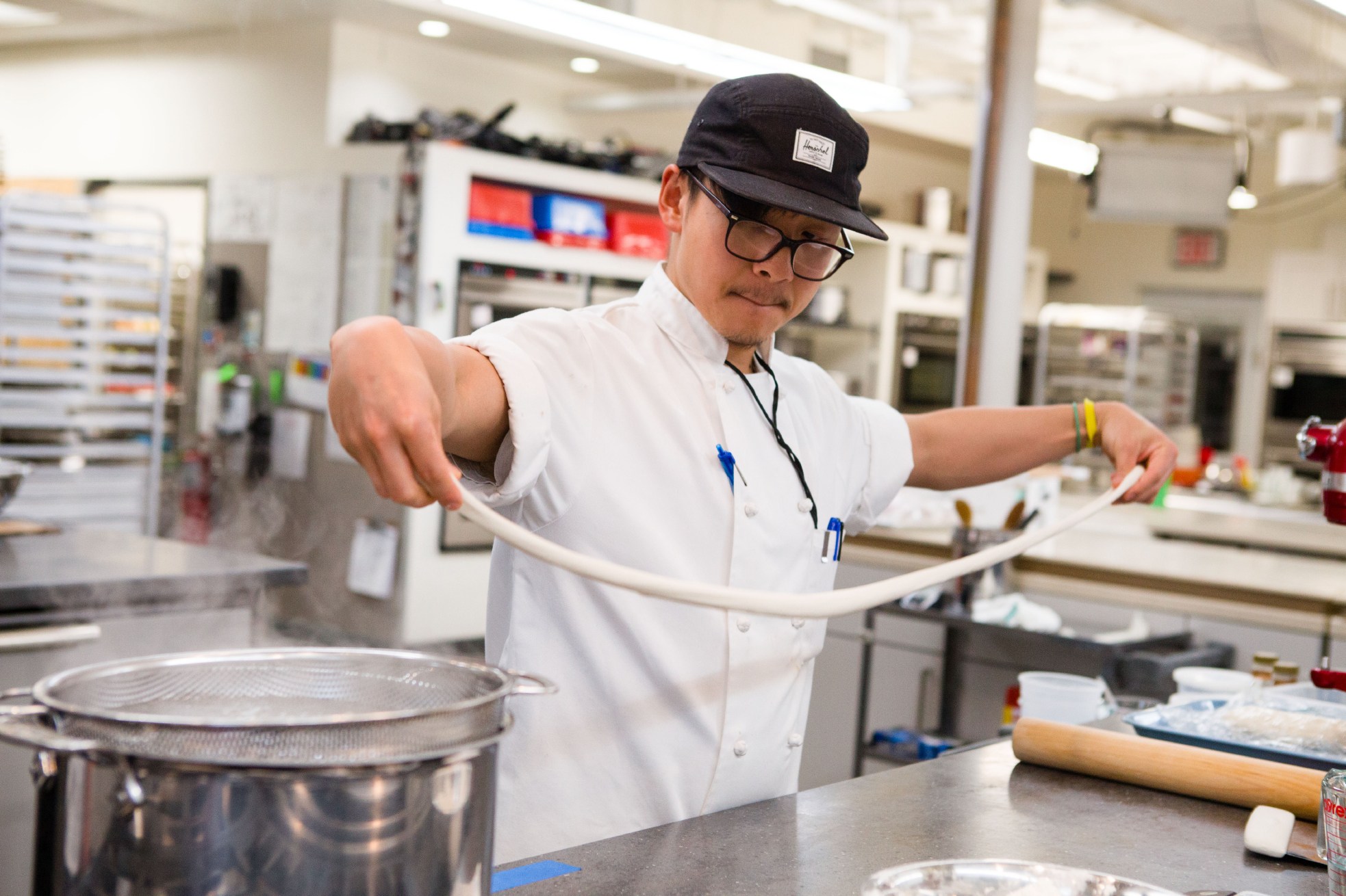 Associate editor Tim Chin stretches dough as he works on a formula for a new recipe for hand-pulled noodles.