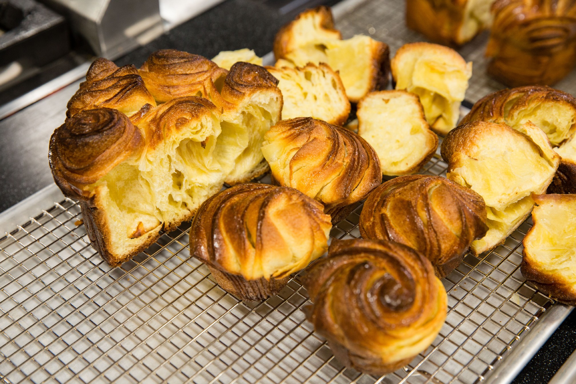 Detail of a loaf of bread and several muffin tin rollls made with braided strips of laminated hot water dough before a tasting of an in-development recipe for Laminated Milk Bread conducted by Cook's Science associate editor Tim Chin.